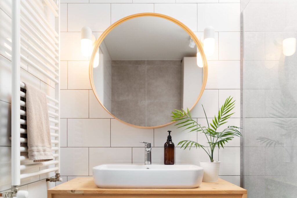 Round Mirror on a bathroom sink with some hair products